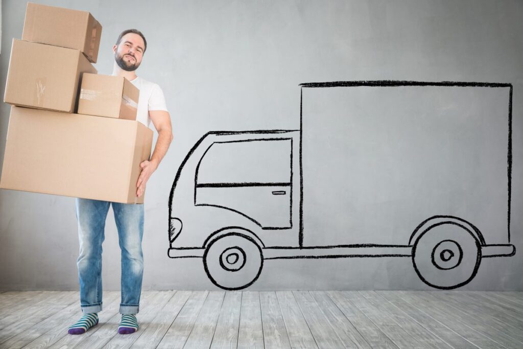 Un homme portant des cartons devant un camion de déménagement