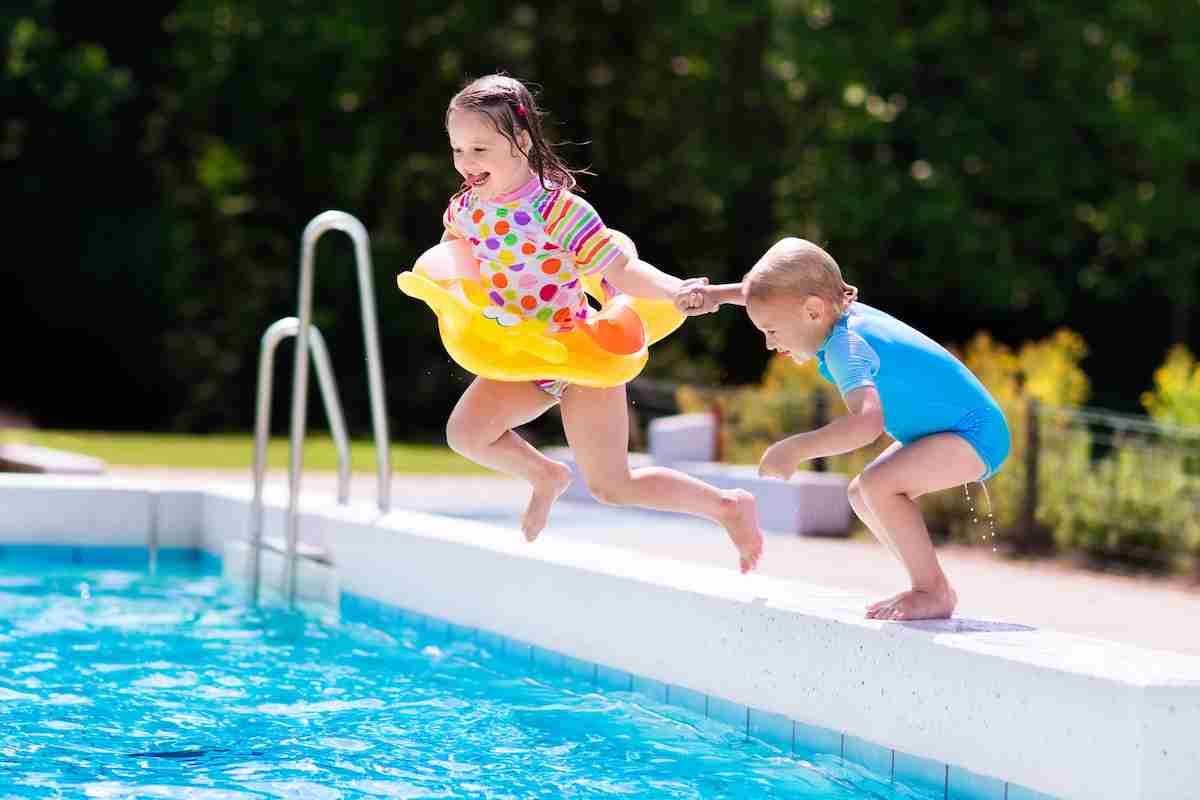 Des enfants sautent dans une piscine