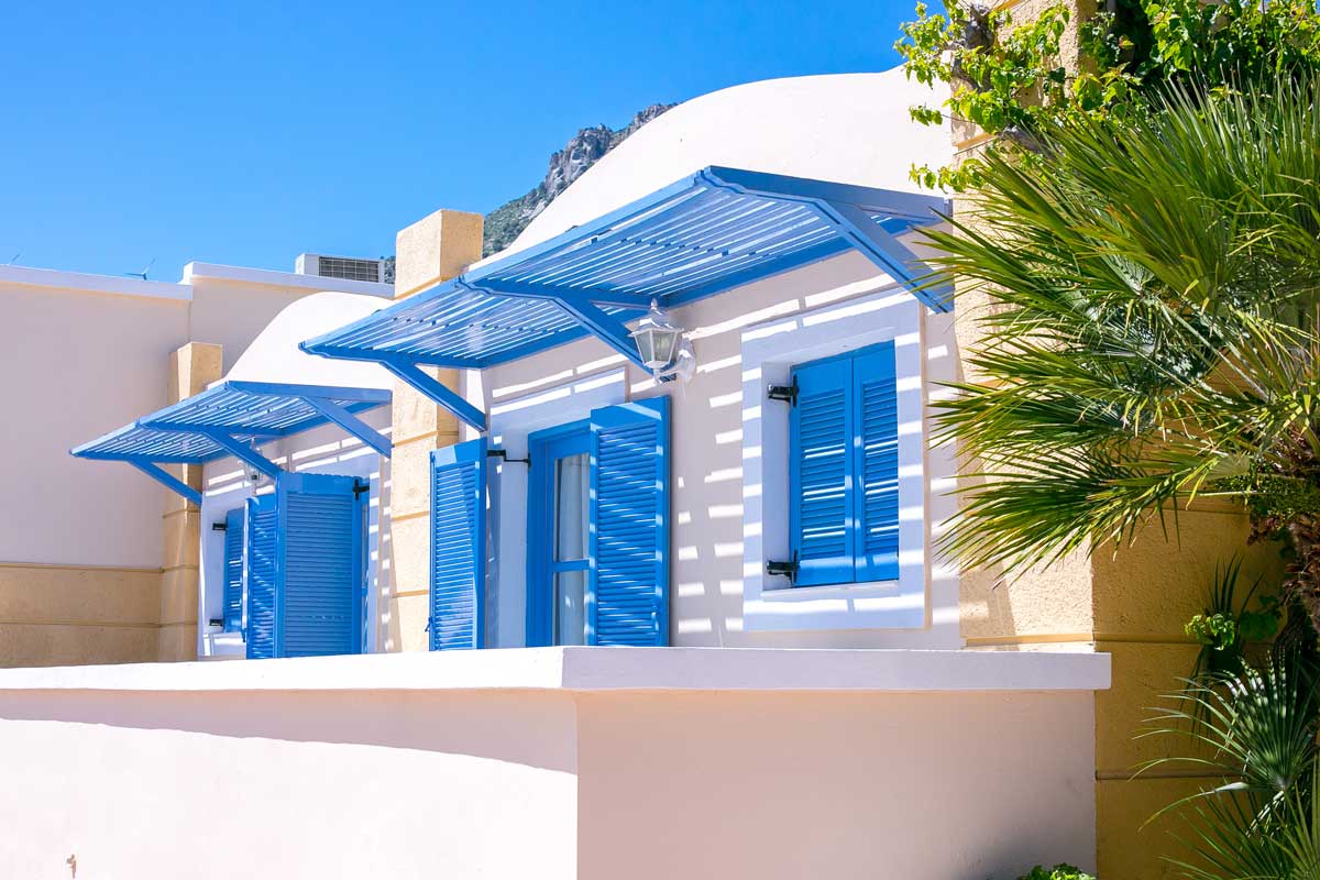 Des volets bleus permettent de sublimer la façade d'une maison blanche